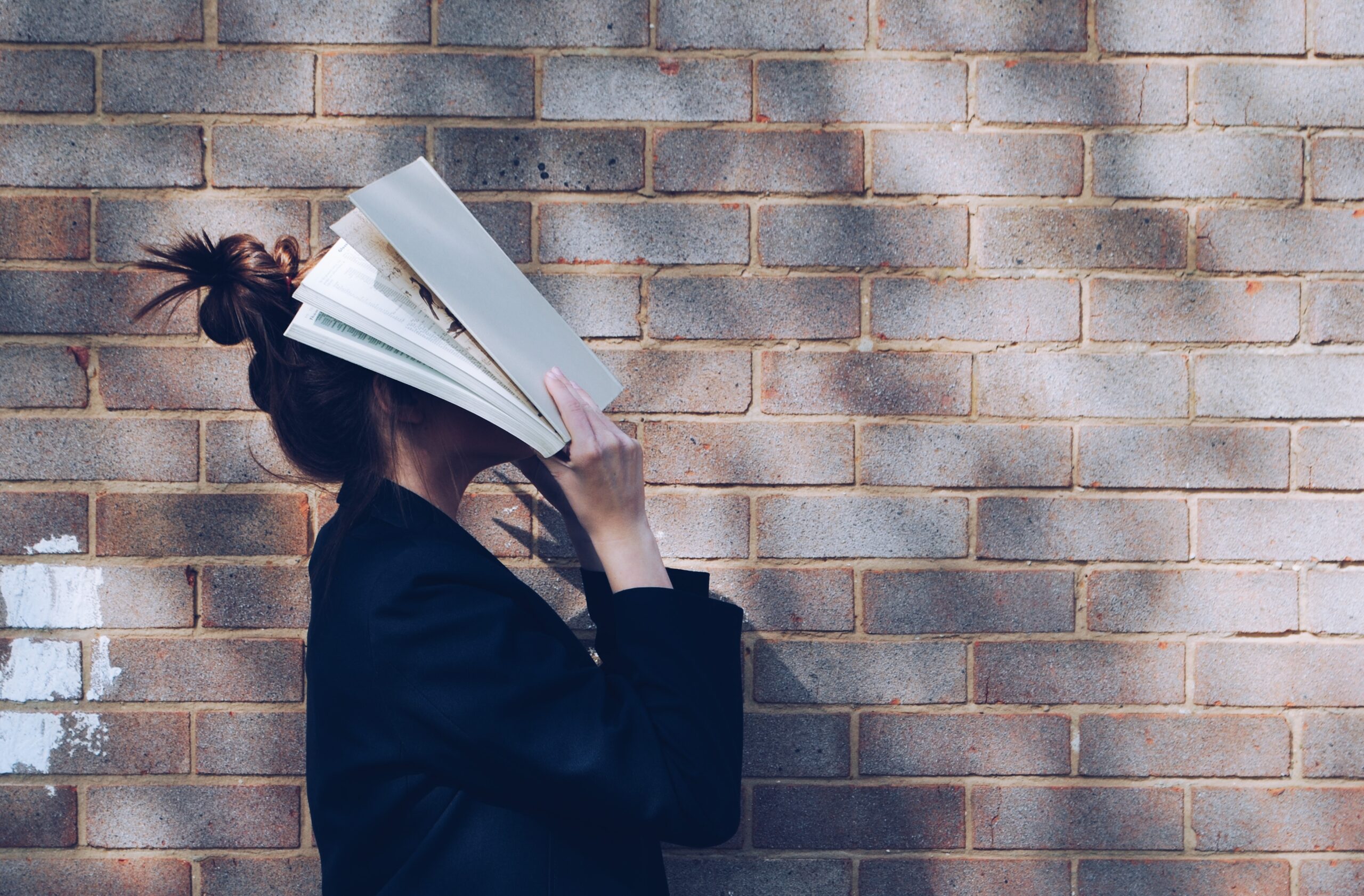 Stressed woman with book over her face