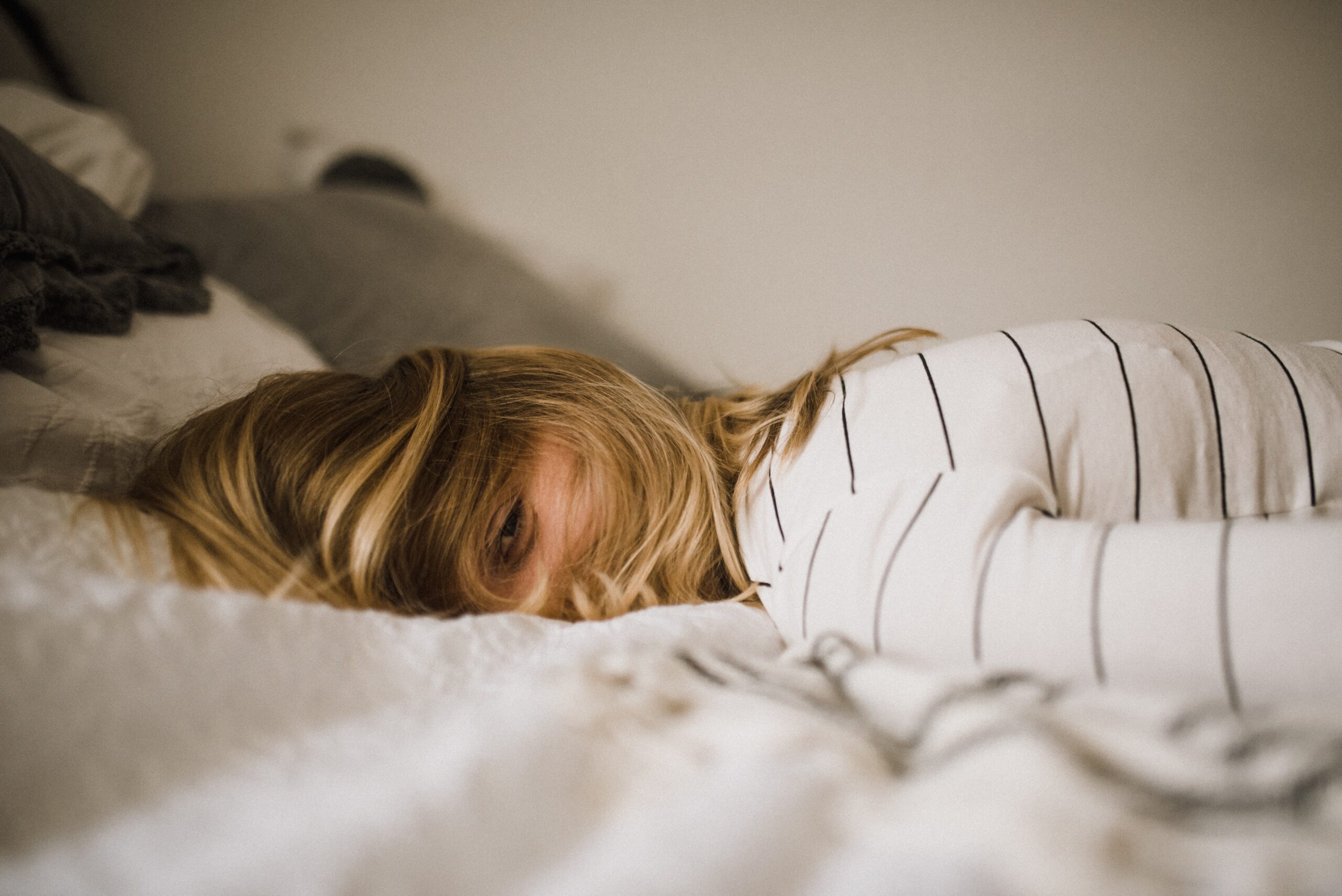 Stressed woman lying face down on a bed