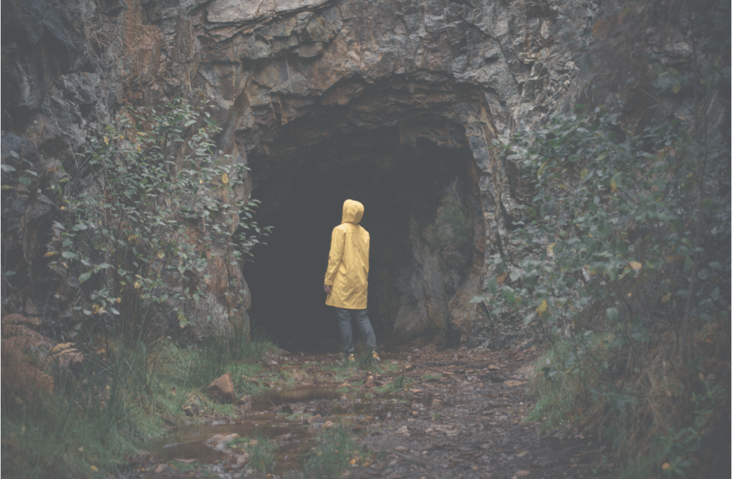 person looking into a cave