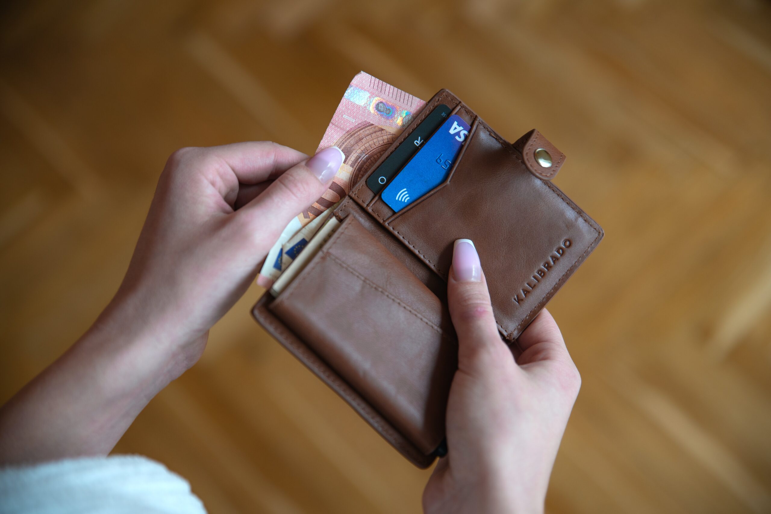 a women holding a wallet with money and cards